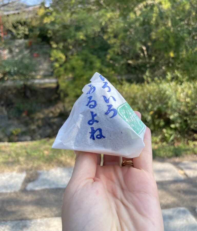 Hand holds an onigiri near the Philosophers Path Kyoto