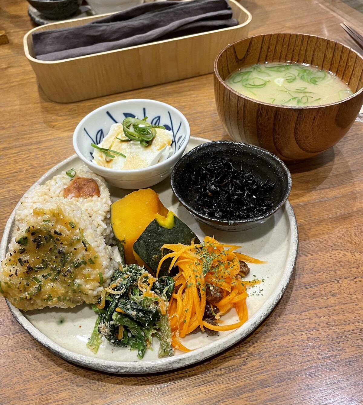 Macrobiotic vegan lunch plate with brown rice onigiri, kabocha and hijiki at Evah Dining in Fukuoka