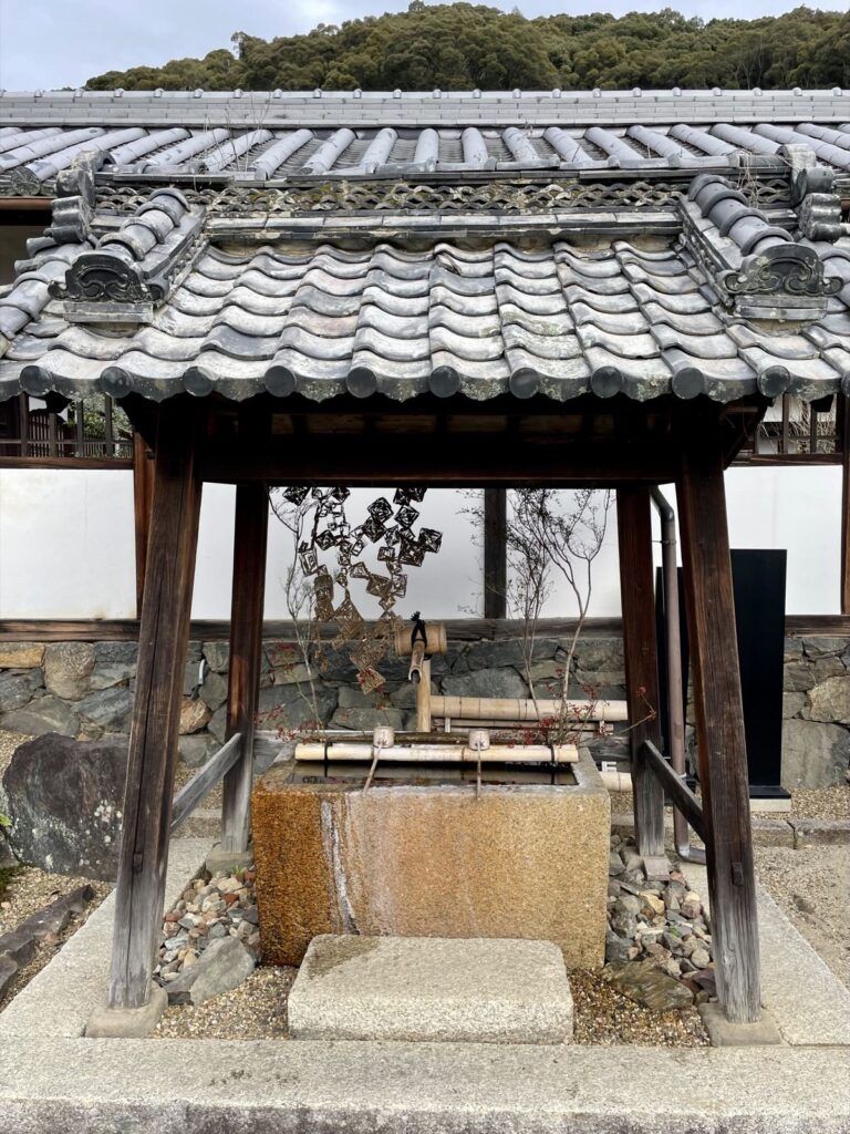 Covered temizuya water basin with bamboo spouts at Kosho-ji Temple in Japan