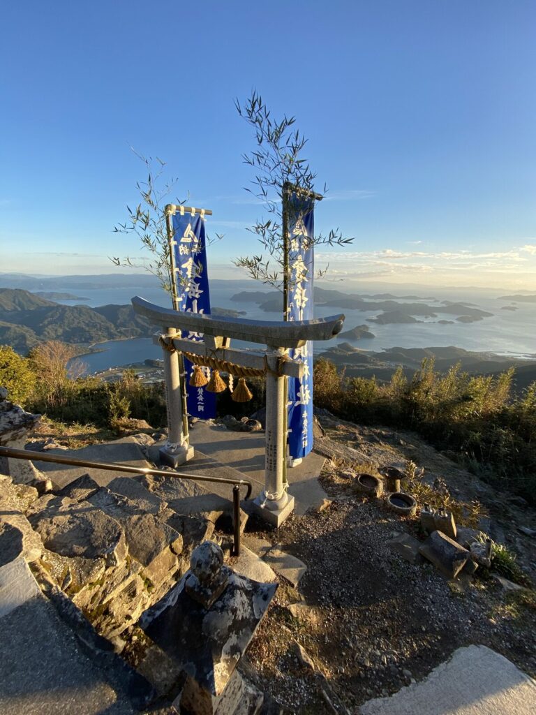 Torii gate of Kuratake Shrine above the Amakusa islands at sunset