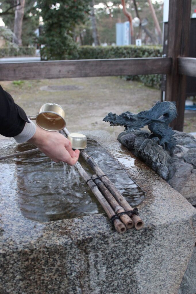 Temple etiquette in Japan: rinsing hands with a ladle at a shrine water basin