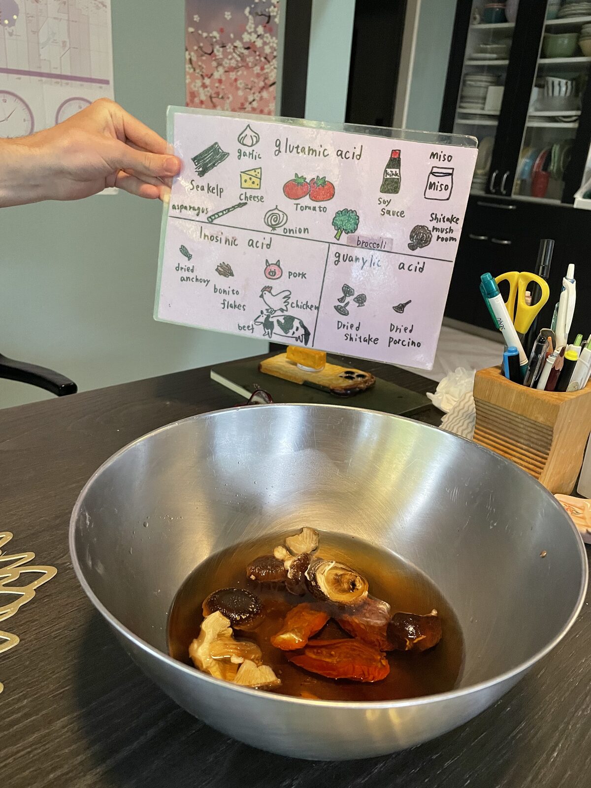 Vegan ramen broth base: dried shiitake and dried tomatoes soaking in water next to a hand-drawn umami chart