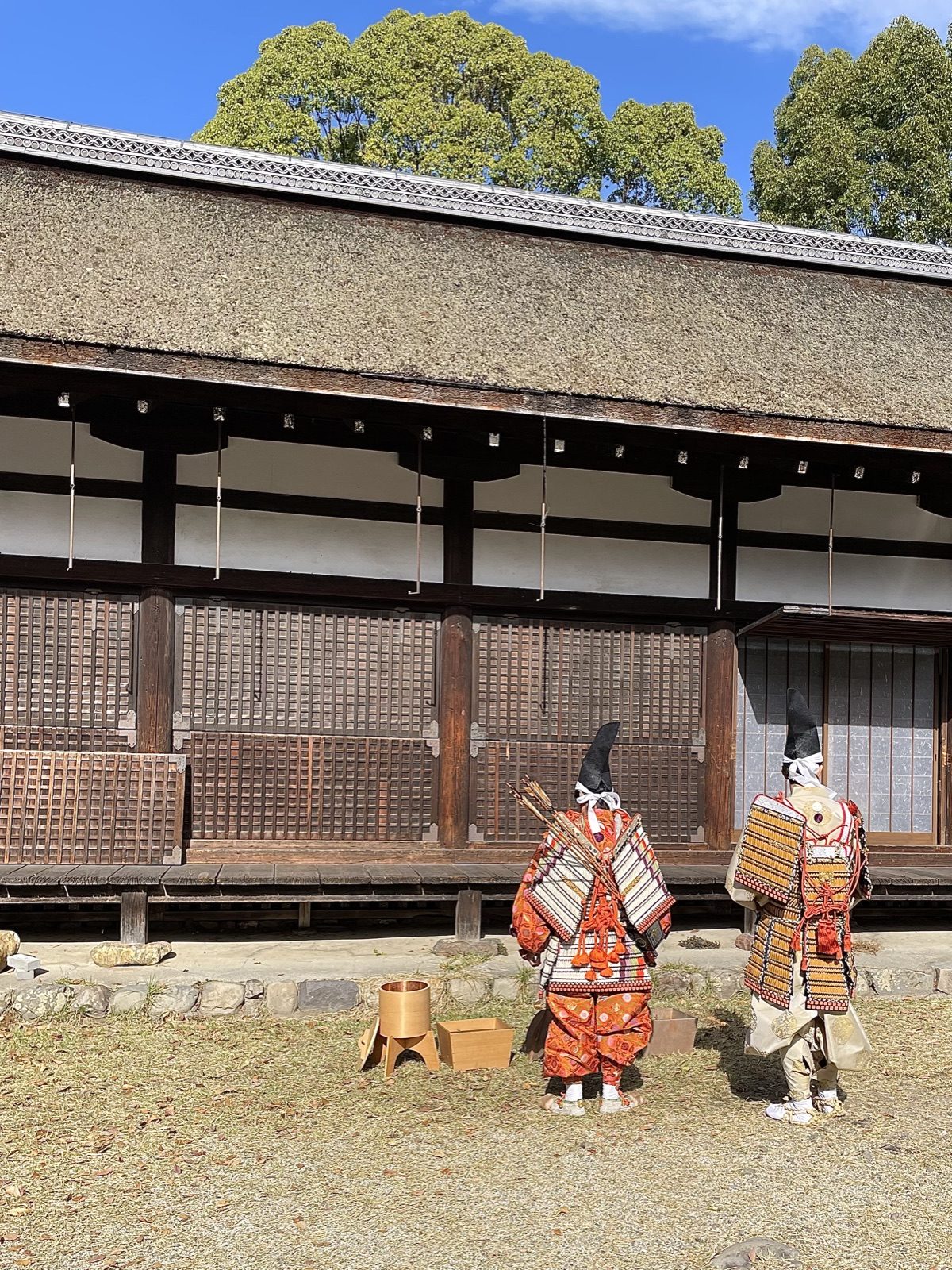 Two children in samurai armour in front of a thatched hall at Kamigamo Shrine
